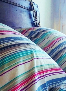 coussin colorés et lit dans une chambre d'hôtes