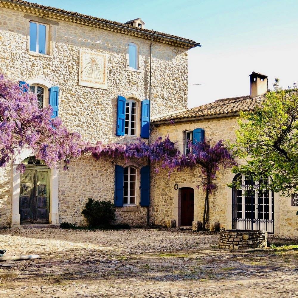 la bastide provençale fleurie d'une belle glycine et sa cour pavée  